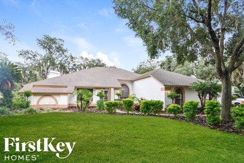 a home with a lawn and trees in front of it