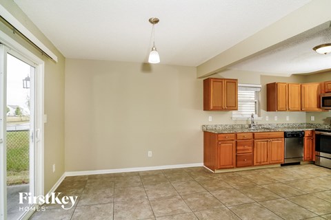 A kitchen with wooden cabinets and a tiled floor.