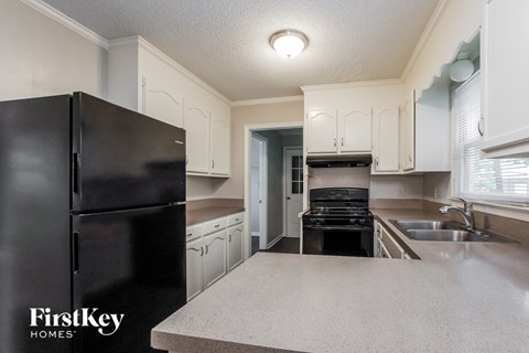 a kitchen with white cabinets and black appliances