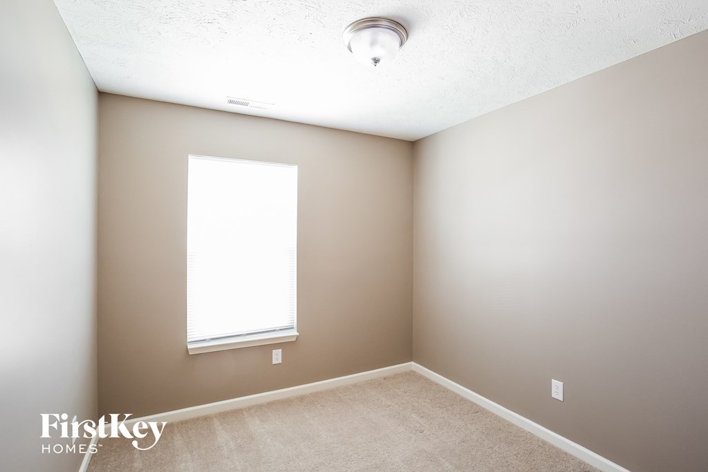 an empty room with a window and a ceiling fan