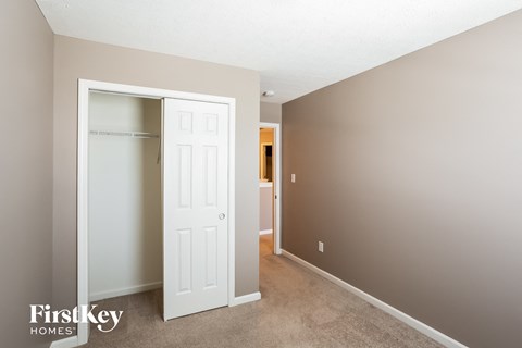 a bedroom with a closet and a white door