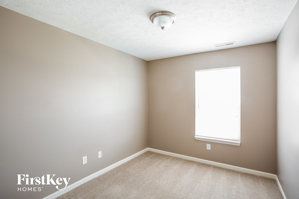 a empty room with a window and a carpeted floor