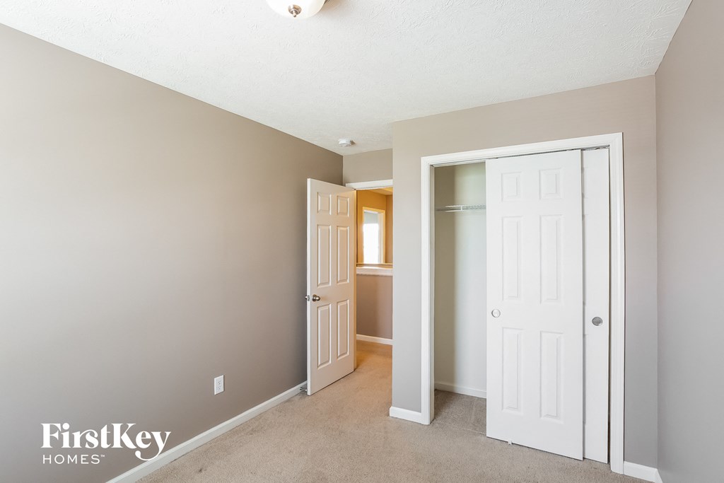 a bedroom with a closet and a door to a bathroom