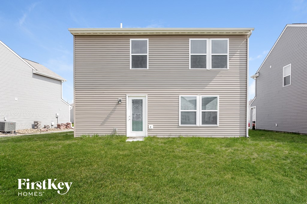the back of a house with a yard in front of it