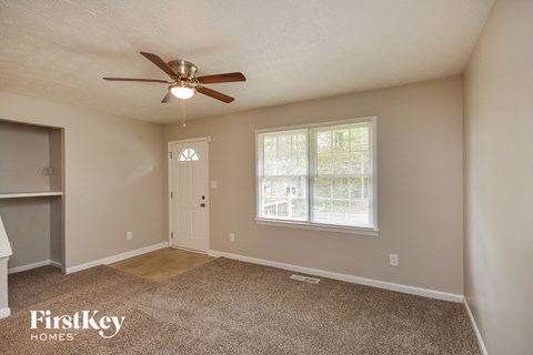 an empty room with a ceiling fan and a window