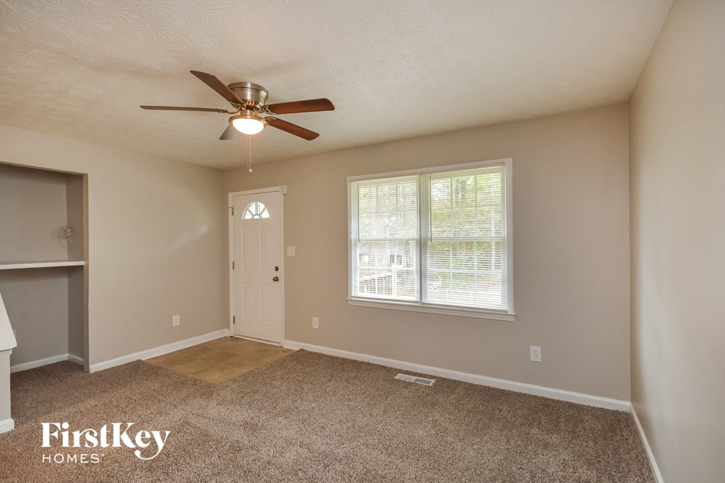 an empty room with a ceiling fan and a window