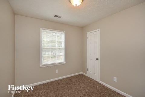 a bedroom with a white door and a window