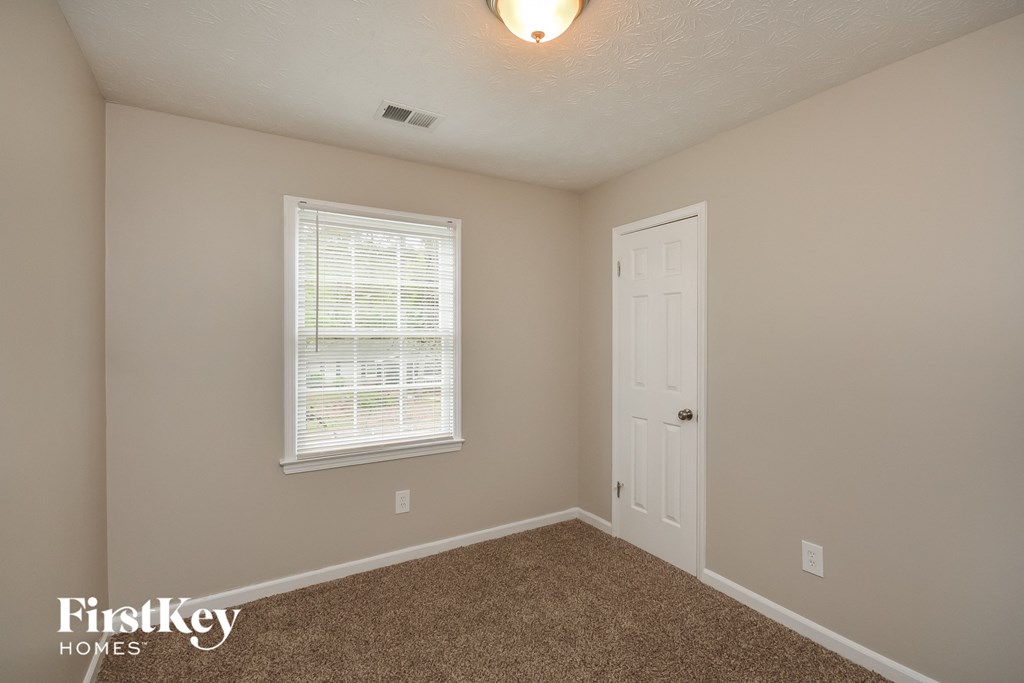 a bedroom with a white door and a window