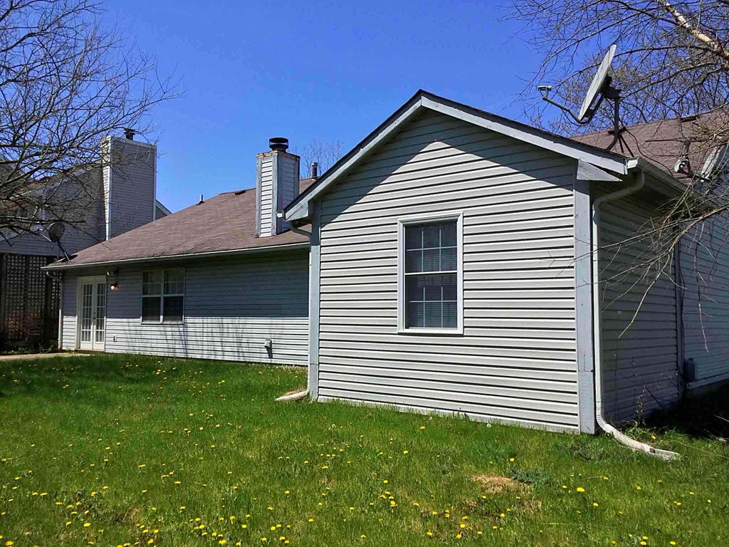 A house with a grey siding and a brown roof.