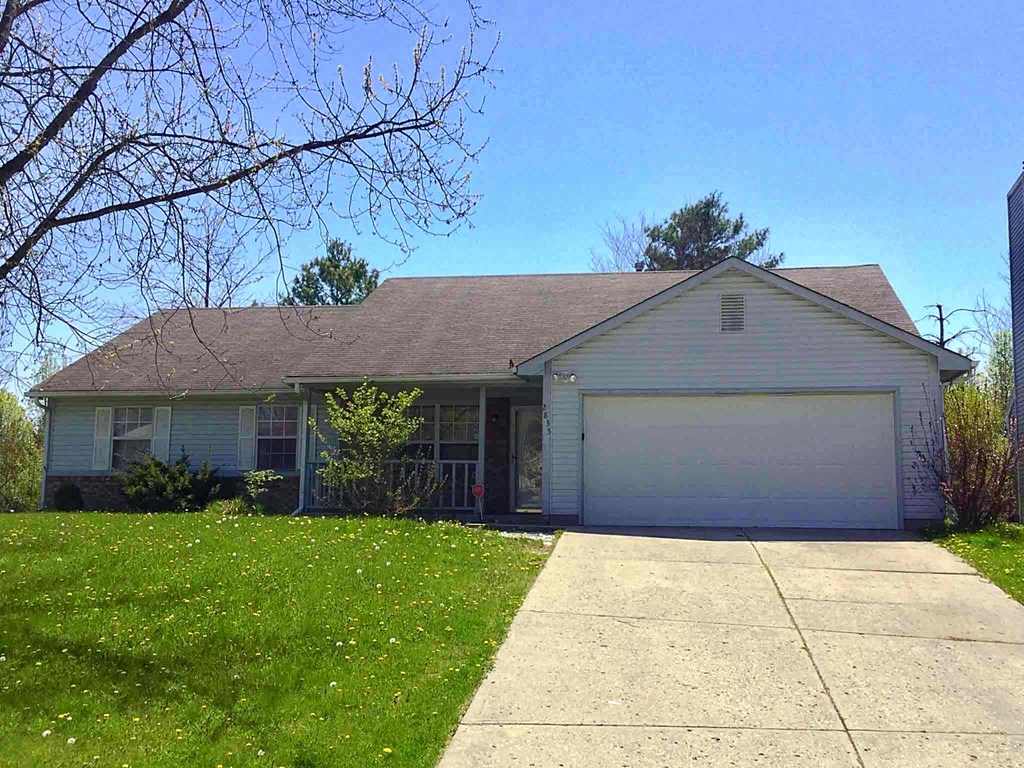 A house with a grey roof and a white garage door.