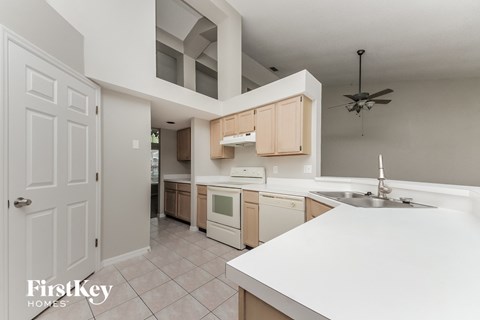A kitchen with a white counter top and a sink.