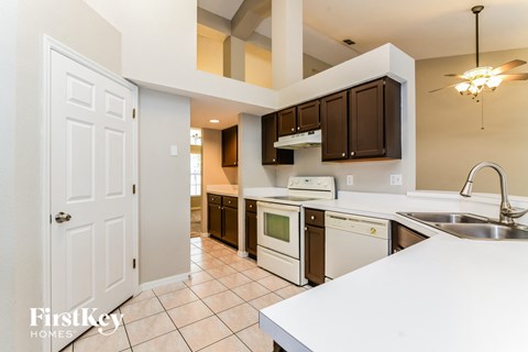 A kitchen with a white counter top and brown cabinets.