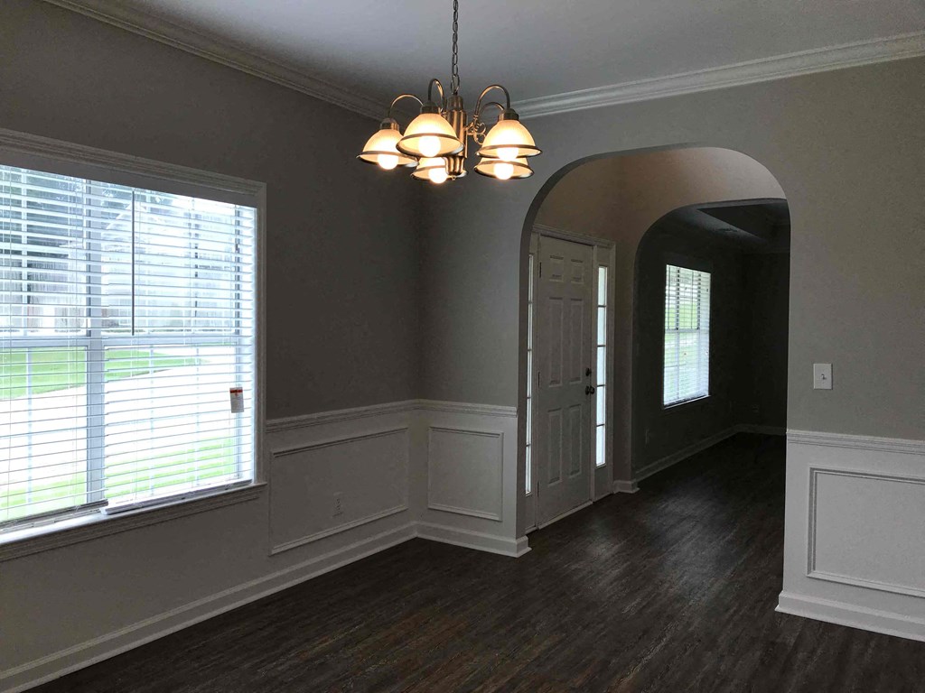 A room with a window, a door, and a chandelier.