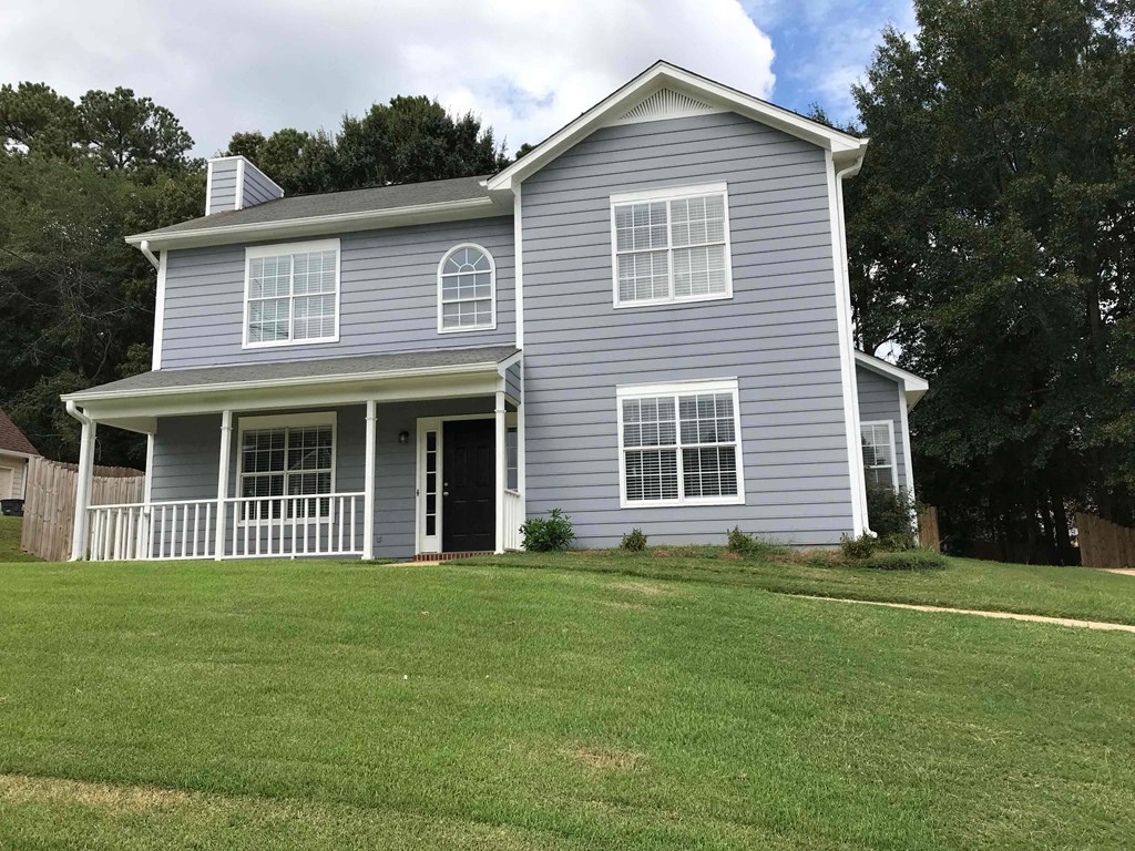 A two-story house with a grey exterior and white trim.