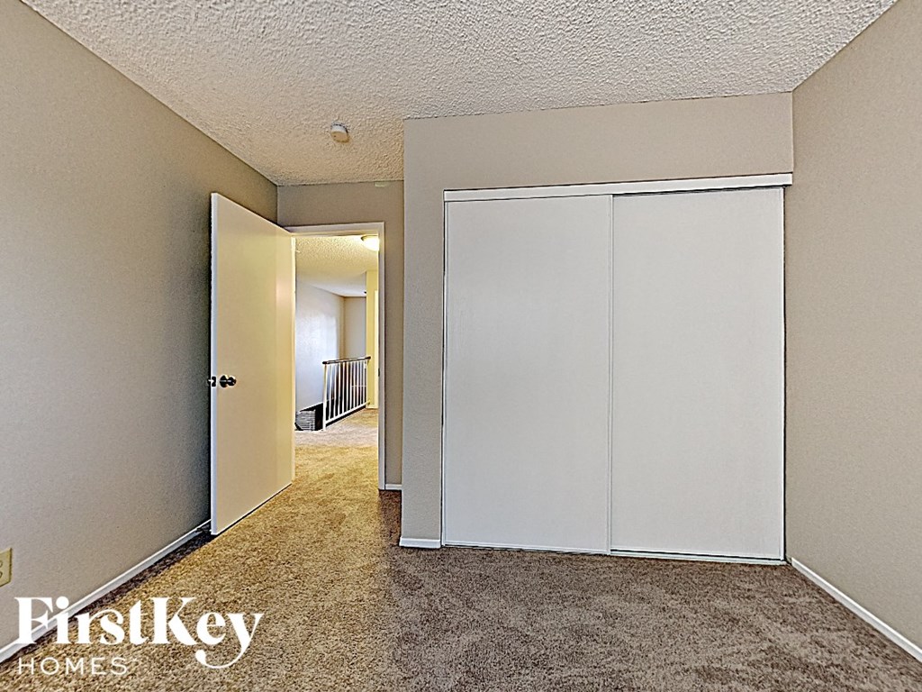 a walk in closet in a bedroom with a door to a hallway