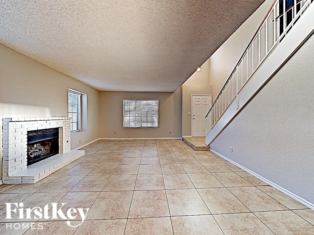 a large living room with a fireplace and a staircase