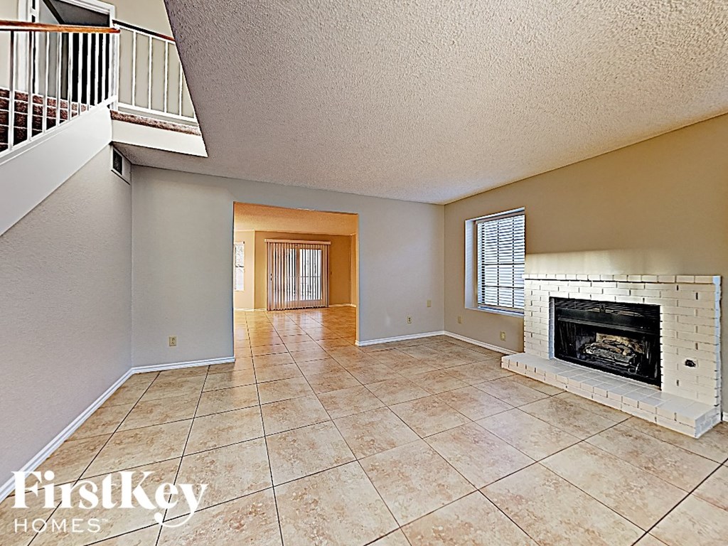 the spacious living room has a fireplace and tile flooring
