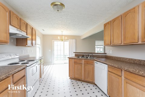 A kitchen with wooden cabinets and a white dishwasher.