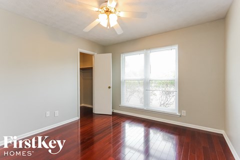 a living room with wood floors and a ceiling fan