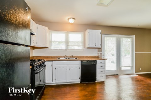 a kitchen with white cabinets and a sink and a refrigerator