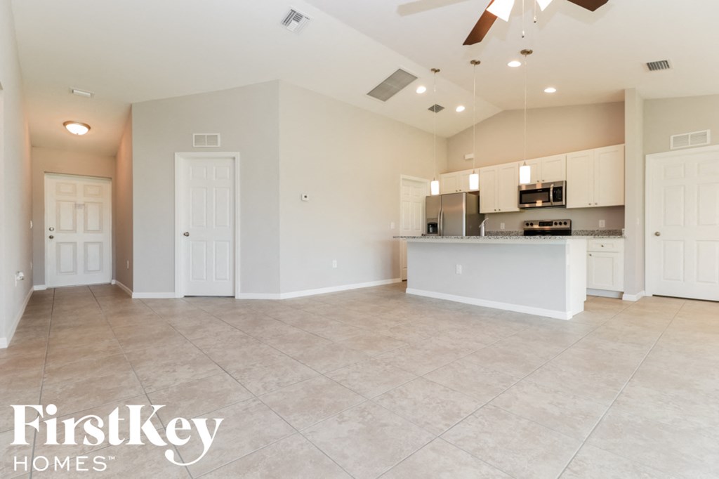 an empty kitchen and living room with a counter top