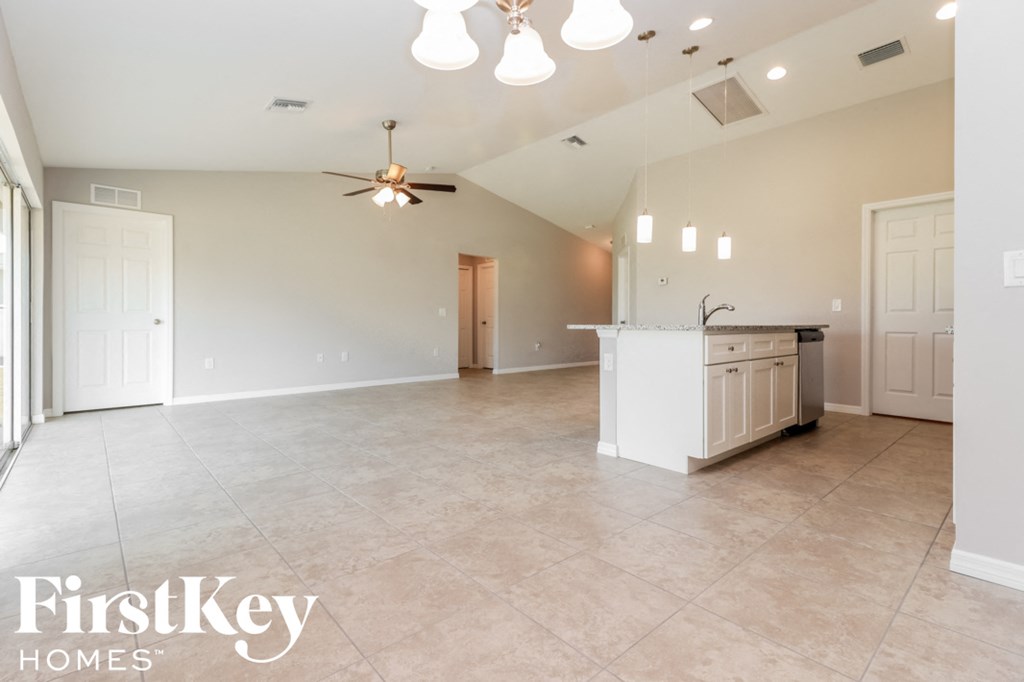 an empty kitchen and living room with a ceiling fan