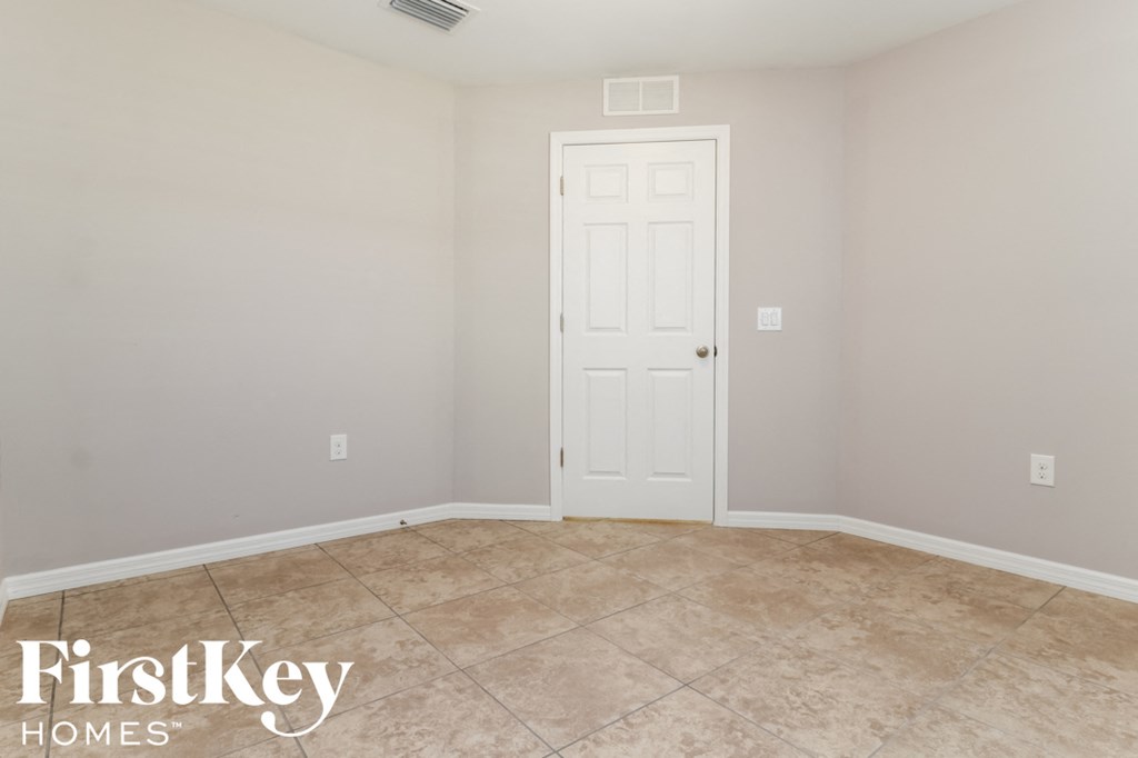 a room with a white door and a tile floor