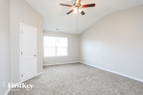 a bedroom with white carpet and a ceiling fan