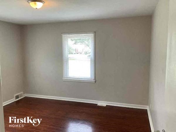 A room with wooden flooring and a window.
