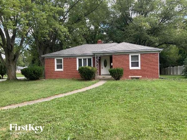 A red brick house with a white door and a small porch.