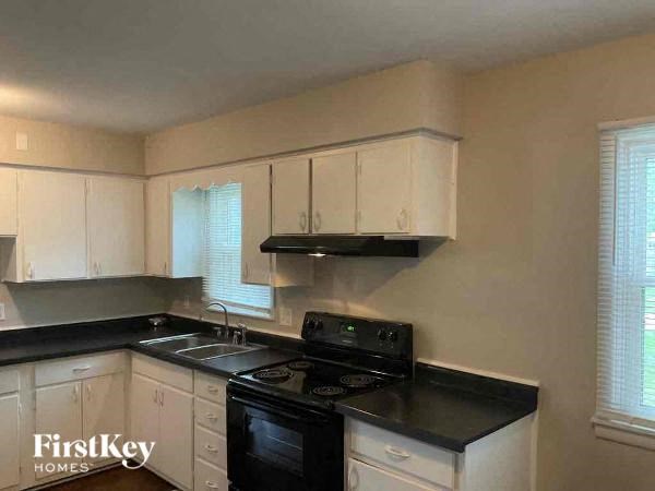 A kitchen with black countertops and white cabinets.