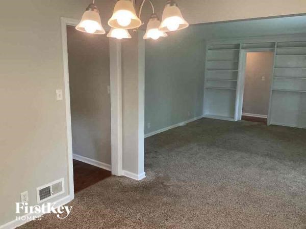 A room with a carpeted floor and a sliding door.