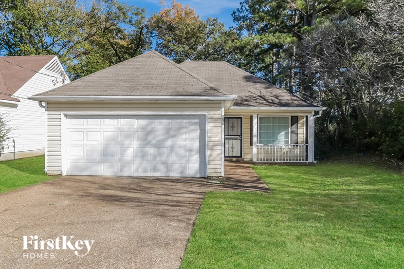 a white garage with a driveway and a white house