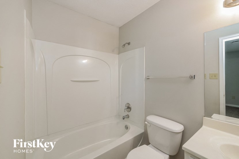 a white bathroom with a toilet and a tub and a sink