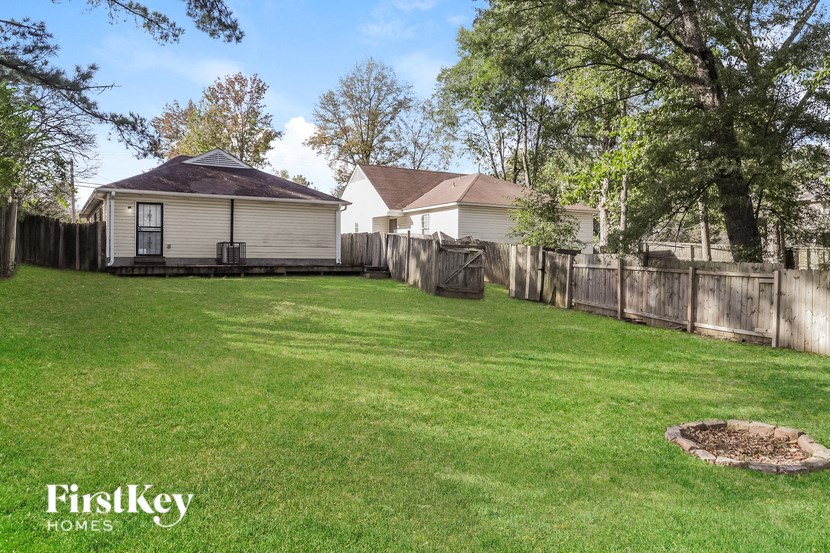 a backyard with a fence and a house
