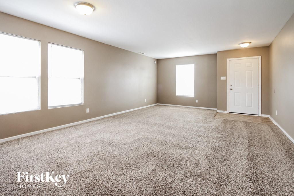 a empty room with a door and three windows