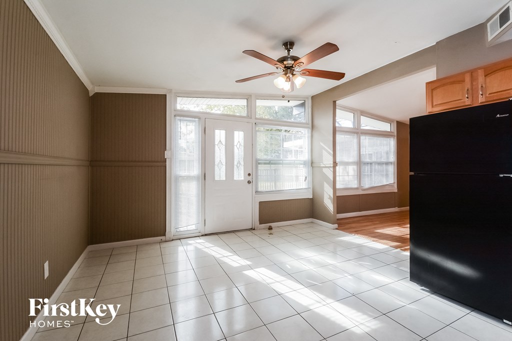 an empty living room with a ceiling fan and a window