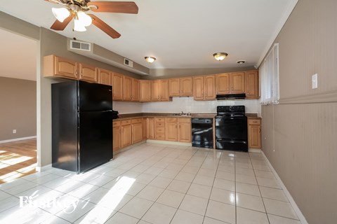a large kitchen with black appliances and wooden cabinets