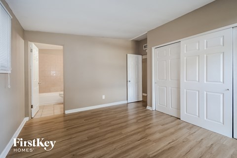 a bedroom with two closets and a door to a bathroom