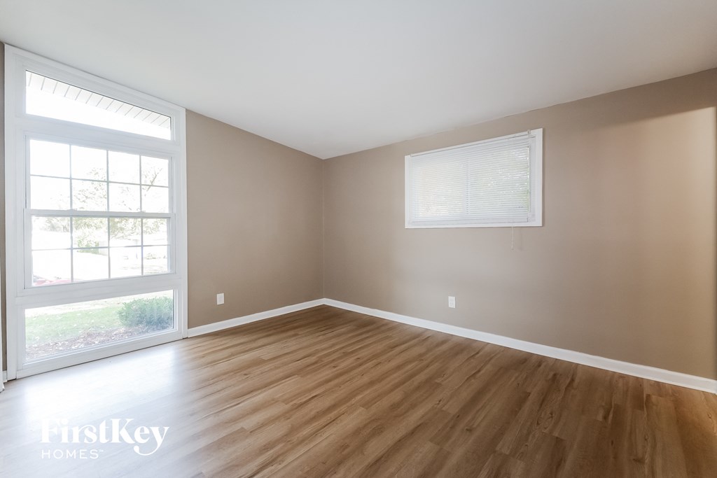 an empty room with wood floors and a window