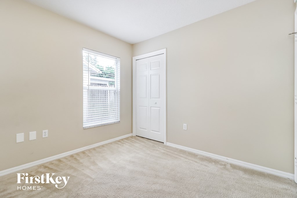 A room with a white door and a window with blinds.