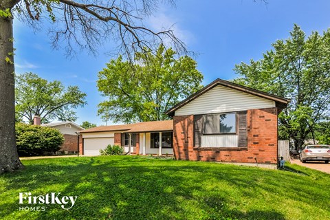 a small brick house with a yard in front of it