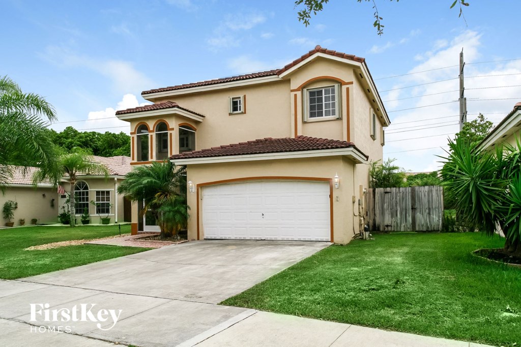 a beige house with a garage and a lawn