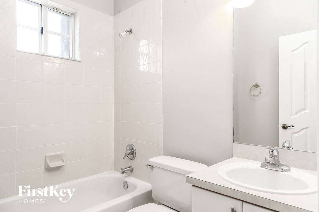 a white bathroom with a sink toilet and tub