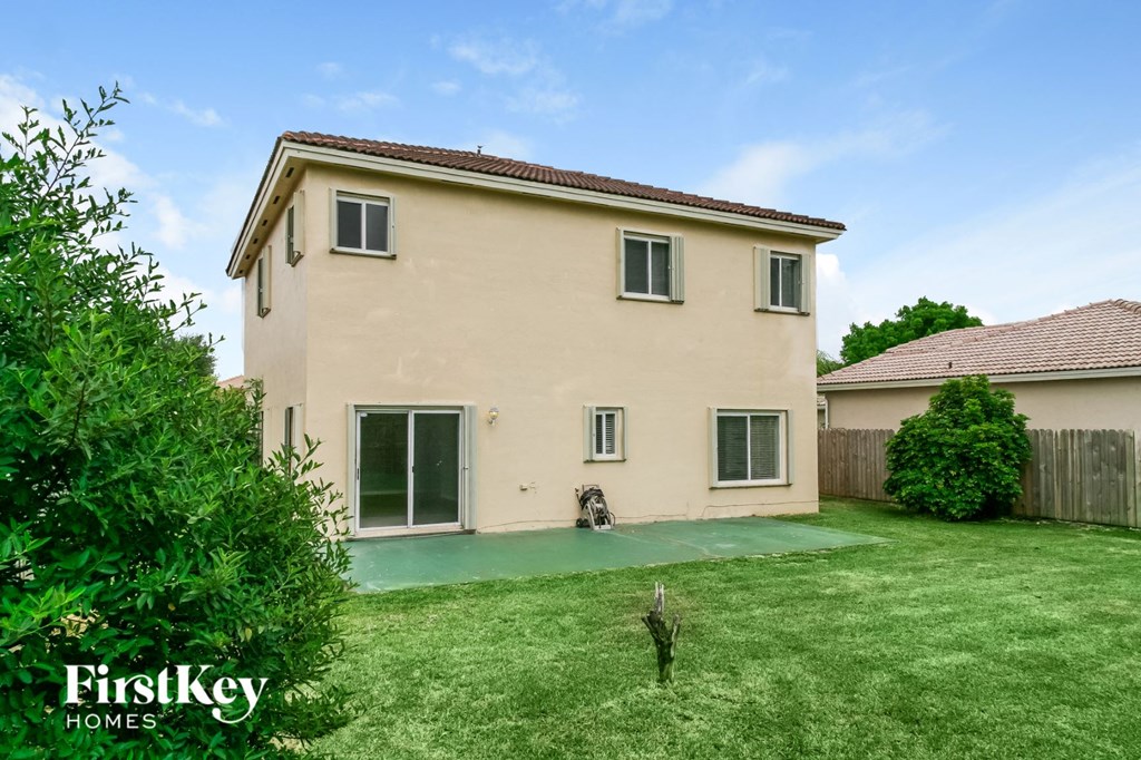 a backyard with a house with a yard and a backdoor