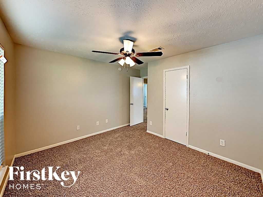 a bedroom with a ceiling fan and a door to a closet