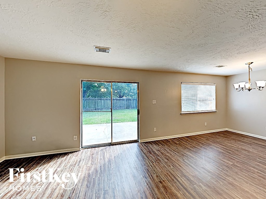 an empty living room with wood floors and a sliding glass door