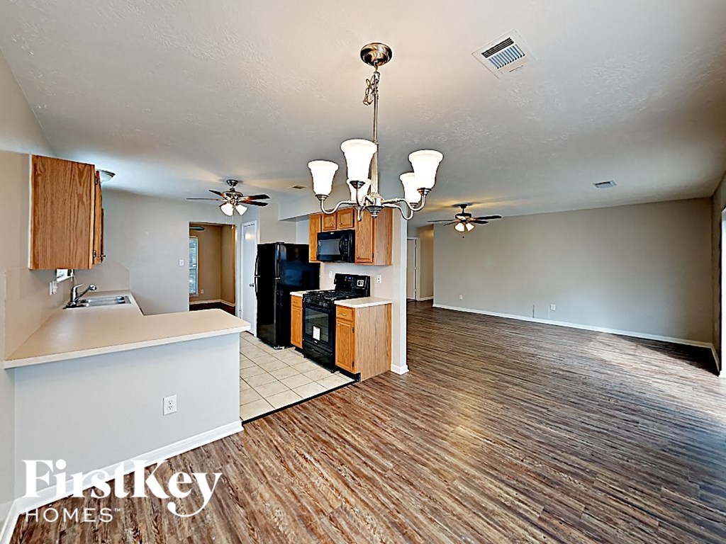 an open kitchen and living room with wood flooring