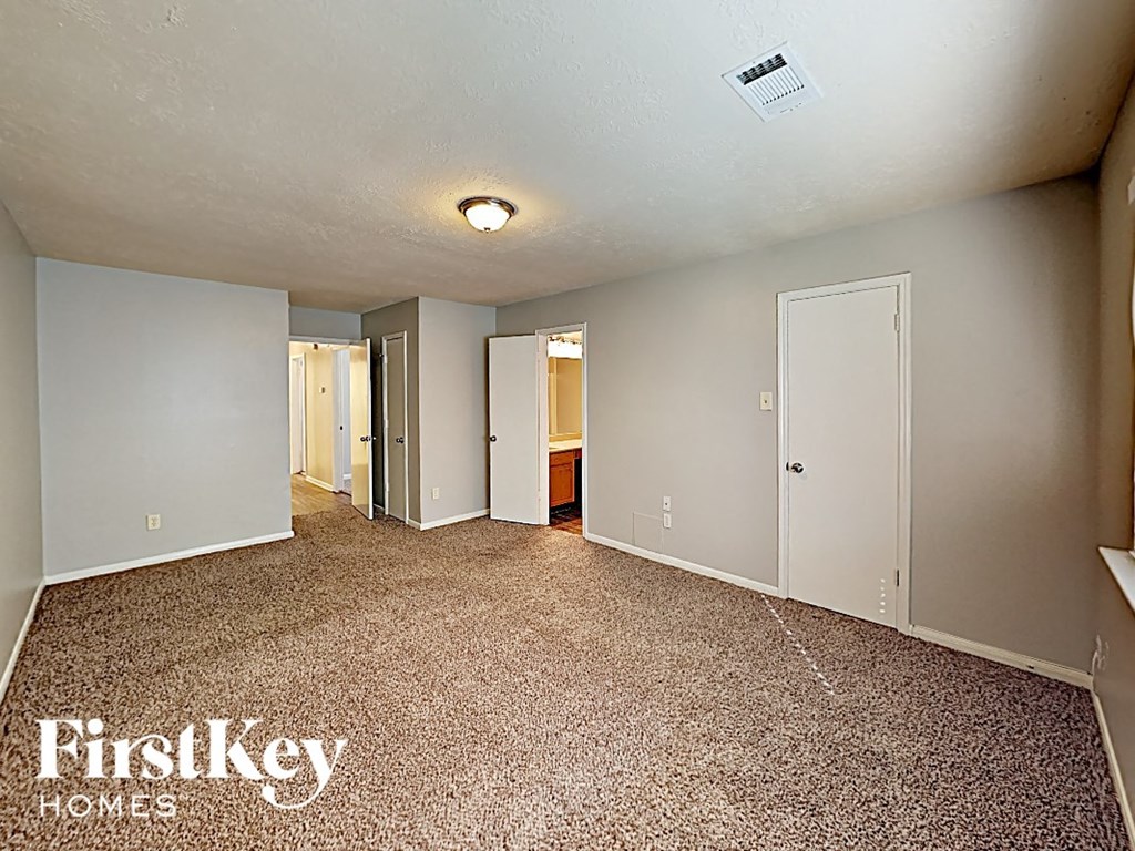 the living room of an empty house with a carpeted floor