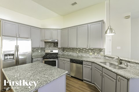 A kitchen with granite countertops and stainless steel appliances.